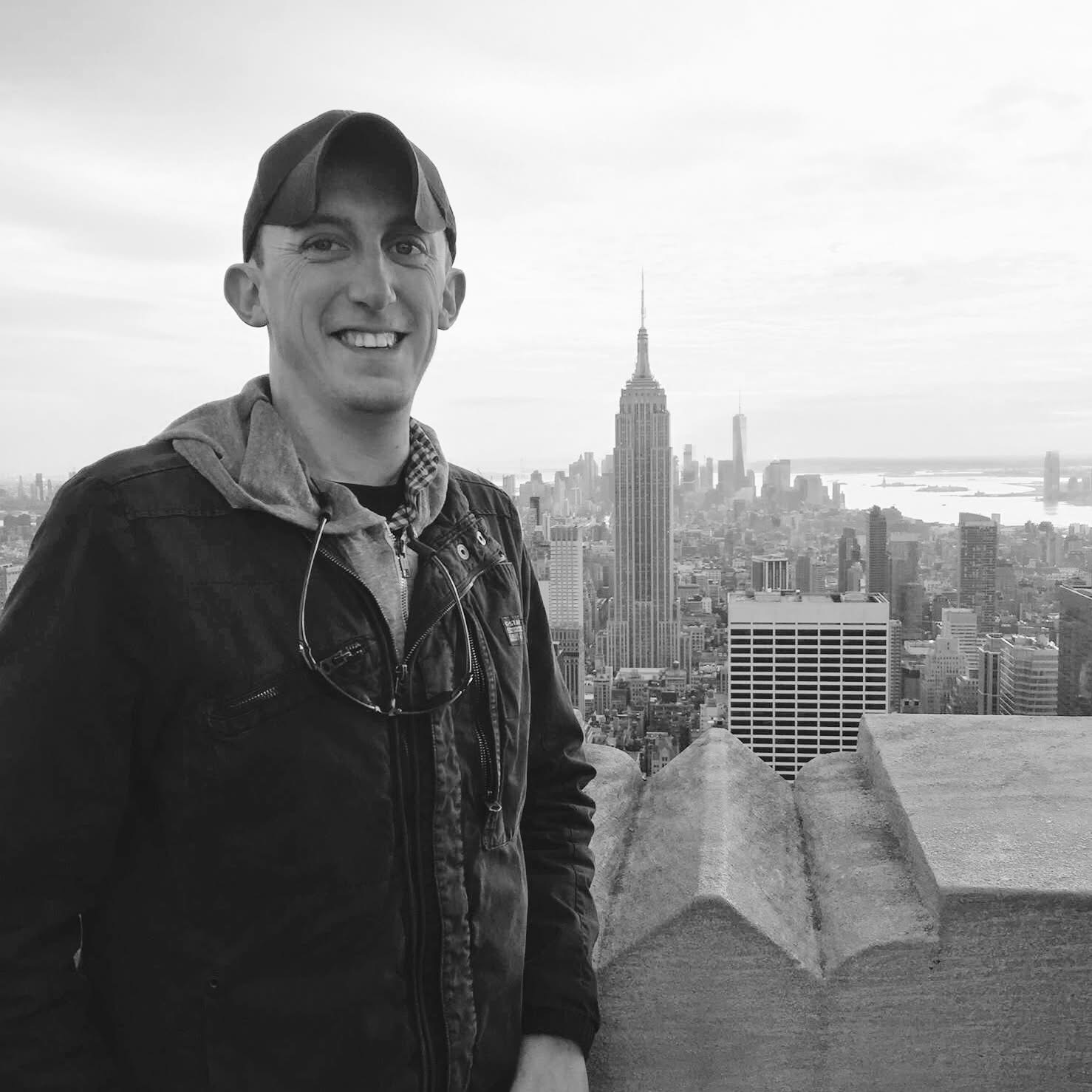 Dustin Mooney at Top of the Rock, New York City, with the Empire State Building behind